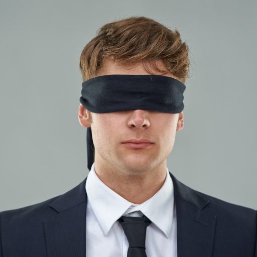 Going blindly into the deal...Cropped view of a young businessman with his eyes blindfolded.